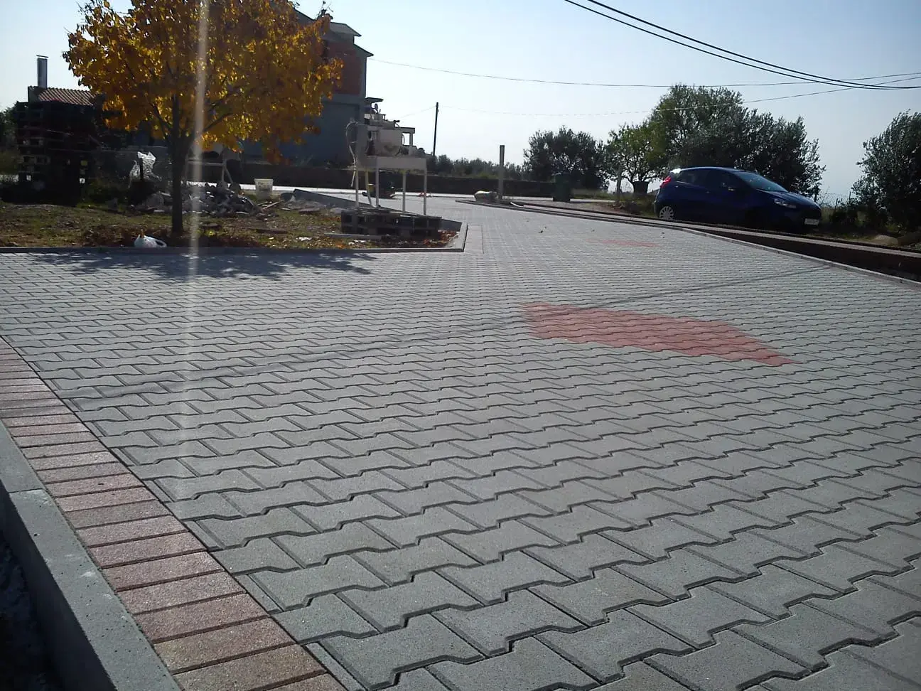 Prostrano popločano dvorište dvobojnim opločnicima s cvjetnom gredicom