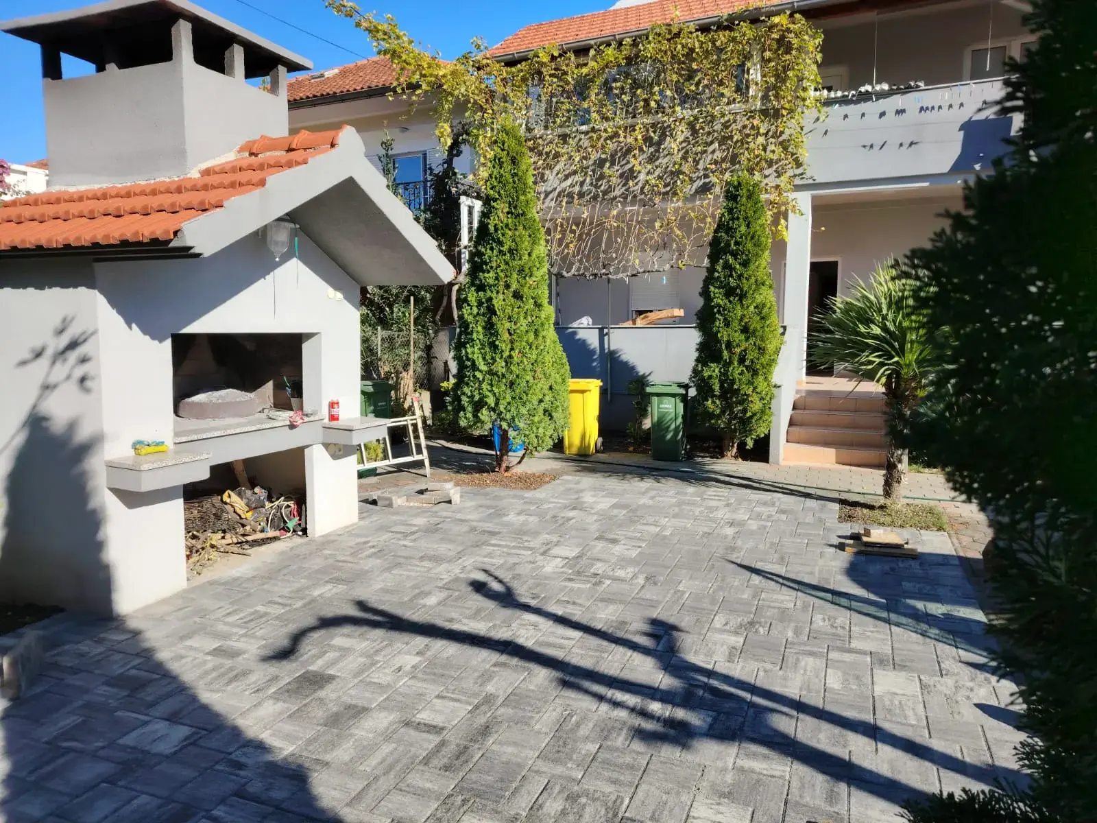 Popločano dvorište sivim opločnicima s vanjskim roštiljem