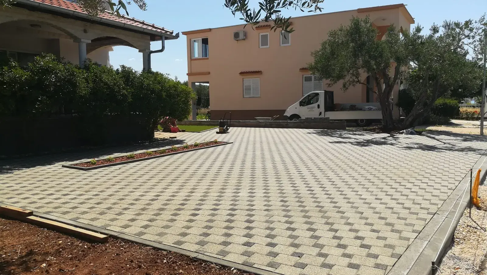 Popločano dvorište bež-sivim opločnicima u kockastom uzorku