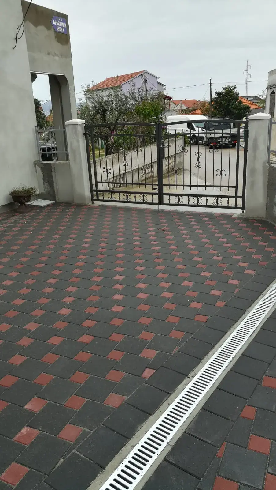Popločan ulaz i dvorište crveno-antracit opločnicima s linijskom odvodnjom uz kapiju